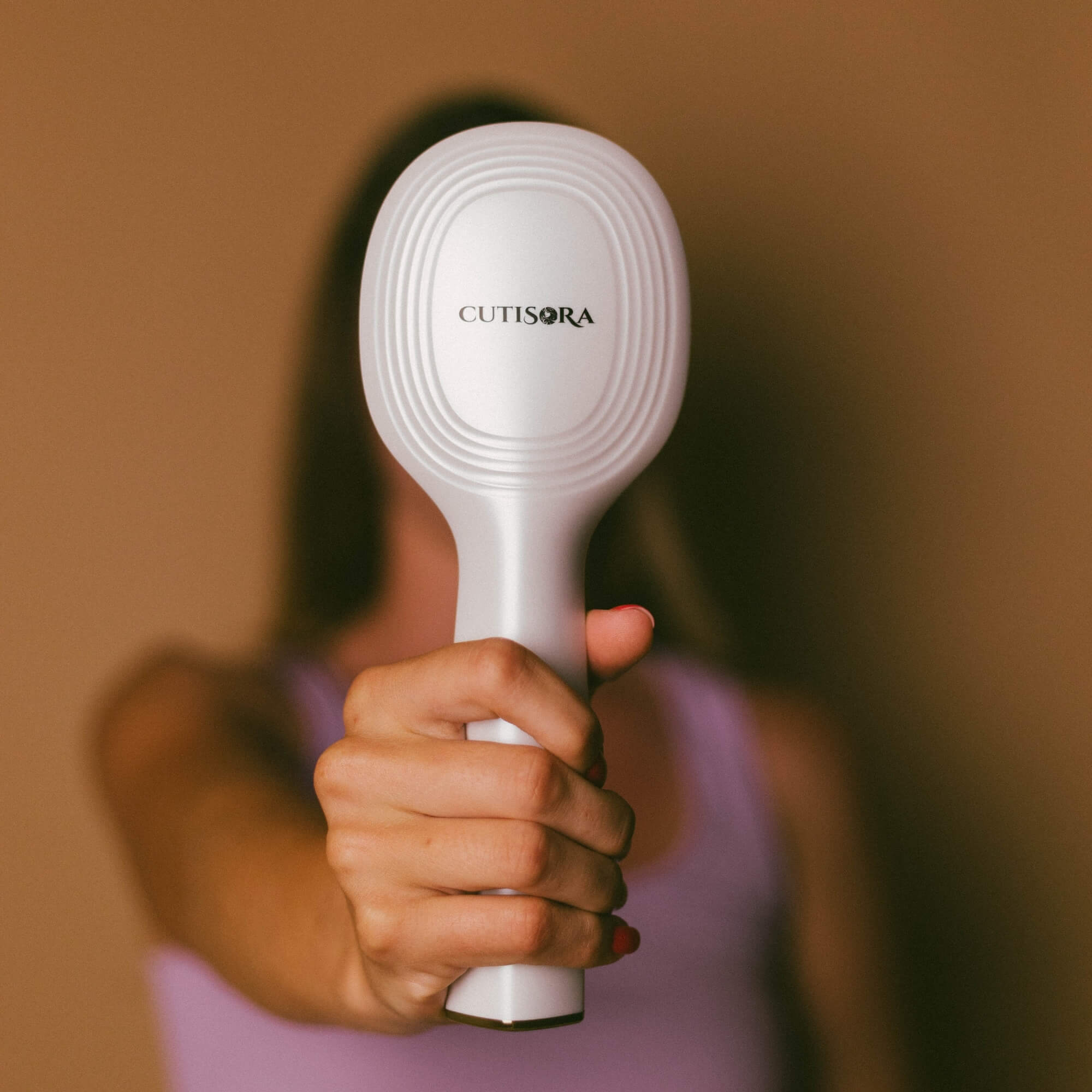 Жена, която държи Масажираща LED четка за коса - Scalp Expert, фронтален изглед.